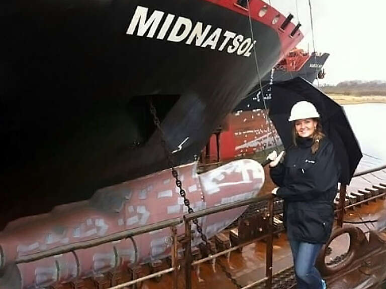 Gina next to a ship port